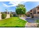 Lush courtyard with green lawns, mature trees, and landscaped walkways at 5877 N Granite Reef Rd # 2203, Scottsdale, AZ 85250