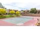 View of the tennis court with yellow trees and grassy area in this apartment community at 5877 N Granite Reef Rd # 2203, Scottsdale, AZ 85250