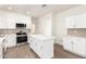 Modern kitchen featuring white cabinets, stainless steel appliances, and an island with stone countertops at 6338 W Hilton Ave, Phoenix, AZ 85043