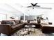 Spacious living room featuring a large leather sofa, stylish decor, and an abundance of natural light at 6621 E Sharon Dr, Scottsdale, AZ 85254