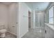 Bright bathroom with a walk-in shower and gray tile flooring at 6815 W Encinas Ln, Phoenix, AZ 85043