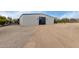 Exterior shot of the barn with gray gravel, sand, and an outdoor gate at 7070 E Lowden Dr, Scottsdale, AZ 85266