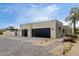 Contemporary home with a large 3-car garage featuring sleek black doors and modern lighting at 7070 E Lowden Dr, Scottsdale, AZ 85266