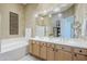 A well-lit bathroom with double sinks, bathtub, and crystal light pendants at 7321 E Crimson Sky Trl, Scottsdale, AZ 85266