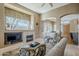 Cozy living room with a fireplace, large window, neutral tones, and comfortable seating at 7321 E Crimson Sky Trl, Scottsdale, AZ 85266