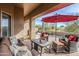 Inviting covered patio with comfortable wicker seating and red umbrella at 7321 E Crimson Sky Trl, Scottsdale, AZ 85266