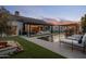 Expansive backyard featuring a pool, lush landscaping, and an outdoor kitchen and bar area at 7508 E Laredo Ln, Scottsdale, AZ 85250
