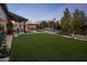 Expansive backyard featuring a sparkling pool, lush lawn, covered patio, and elegant landscaping at 7508 E Laredo Ln, Scottsdale, AZ 85250