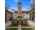 Backyard featuring an outdoor dining area with brick fireplace and manicured greenery at 7508 E Laredo Ln, Scottsdale, AZ 85250