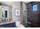 A modern bathroom featuring a walk-in shower, a concrete sink, and stylish black fixtures at 7508 E Laredo Ln, Scottsdale, AZ 85250