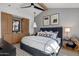 Comfortable bedroom with wooden accents, a large grey headboard, soft lighting and a large window at 7508 E Laredo Ln, Scottsdale, AZ 85250