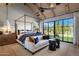 A bright bedroom with a four poster bed, vaulted ceiling, and access to a private outdoor area with lush green grass at 7508 E Laredo Ln, Scottsdale, AZ 85250