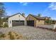 A home featuring a three car garage, brick accents, a paved driveway and manicured lawn at 7508 E Laredo Ln, Scottsdale, AZ 85250