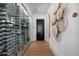 Stylish hallway featuring a custom wine cellar and artistic wall decor at 7508 E Laredo Ln, Scottsdale, AZ 85250