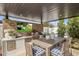 Luxurious outdoor living space featuring a built-in outdoor kitchen, dining area and TV at 7508 E Laredo Ln, Scottsdale, AZ 85250