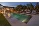 Beautiful swimming pool with water features, lounge chairs, and covered outdoor bar area at 7508 E Laredo Ln, Scottsdale, AZ 85250
