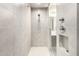 Modern shower with gray tile, handheld shower head and convenient recessed shelf at 7515 W Warner St, Phoenix, AZ 85043