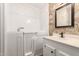 Bathroom featuring walk-in bathtub with safety door and white vanity with stone textured wall at 7714 E Calypso Ave, Mesa, AZ 85208