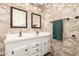Bathroom featuring double sinks, granite vanity top, and framed mirrors over white vanity at 7714 E Calypso Ave, Mesa, AZ 85208