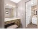 Bathroom vanity with mirror and vanity lights adjacent to walk-in bathtub with safety door at 7714 E Calypso Ave, Mesa, AZ 85208