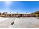 Wide view of the home's exterior featuring ample parking space, an enclosed patio and neutral paint at 7714 E Calypso Ave, Mesa, AZ 85208