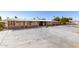 Single-story home with a large parking area, and a partially enclosed porch; with a well-maintained yard at 7714 E Calypso Ave, Mesa, AZ 85208