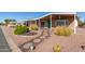 Inviting home featuring a quaint walkway leading to a covered porch, surrounded by desert landscaping at 7714 E Calypso Ave, Mesa, AZ 85208