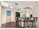 Kitchen with a breakfast bar featuring seating for three people with laminate countertops and wood style laminate flooring at 7714 E Calypso Ave, Mesa, AZ 85208
