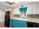 Galley kitchen featuring blue cabinets, sleek black appliances, laminate countertops, and mosaic style backsplash at 7714 E Calypso Ave, Mesa, AZ 85208