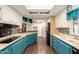 Bright kitchen featuring blue cabinets, sleek black appliances, a breakfast bar, and ample counter space at 7714 E Calypso Ave, Mesa, AZ 85208
