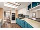 Well-lit kitchen featuring blue cabinets, a black cooktop, white appliances, and a breakfast bar with seating at 7714 E Calypso Ave, Mesa, AZ 85208