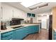 Bright kitchen featuring blue cabinets, sleek black appliances, a breakfast bar, and ample counter space at 7714 E Calypso Ave, Mesa, AZ 85208