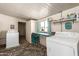 Bright laundry room with washer, dryer, built-in storage and workspace; featuring a patterned rug and natural light at 7714 E Calypso Ave, Mesa, AZ 85208