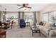 Comfortable living room with adjacent dining area, featuring large windows and neutral decor at 7714 E Calypso Ave, Mesa, AZ 85208