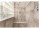 Updated walk-in shower with tile surround, glass block window, and shower seat at 7714 E Calypso Ave, Mesa, AZ 85208