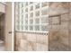 Updated walk-in shower with tile surround and glass block window detail at 7714 E Calypso Ave, Mesa, AZ 85208