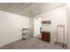 A simple spare room with neutral carpet and walls; containing shelving and wooden cabinet at 7714 E Calypso Ave, Mesa, AZ 85208