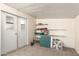 A basic storage room with white walls and door, carpeted floor; featuring shelves and assorted items at 7714 E Calypso Ave, Mesa, AZ 85208