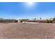 Wide shot of the property featuring a spacious gravel yard, view of the house, and neighboring properties at 7714 E Calypso Ave, Mesa, AZ 85208