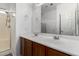 Bathroom with double vanity, wood cabinets, large mirror, and walk-in shower at 7739 E Butte St, Mesa, AZ 85207