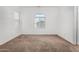 Neutral bedroom with a large window providing natural light, and neutral carpeting at 7739 E Butte St, Mesa, AZ 85207