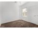 Clean, neutral bedroom with carpet, window, and white trim creates a bright, open feel at 7739 E Butte St, Mesa, AZ 85207