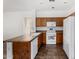 Functional kitchen features wood cabinetry, white appliances, and tile flooring at 7739 E Butte St, Mesa, AZ 85207