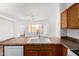 Kitchen featuring wood cabinets, stainless steel faucet, and an open view to the living area at 7739 E Butte St, Mesa, AZ 85207