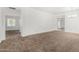 Open-concept living area with plush carpeting and a seamless flow to other rooms in the house at 7739 E Butte St, Mesa, AZ 85207