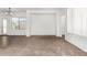 Open-concept living area with neutral carpet and view to the front door at 7739 E Butte St, Mesa, AZ 85207