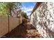 Narrow side yard with desert landscaping and a brick wall for privacy at 7739 E Butte St, Mesa, AZ 85207
