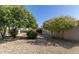 View of the backyard with rock ground cover and mature trees around the perimeter of the property at 8150 E Mitchell Dr, Scottsdale, AZ 85251