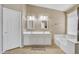Bright Primary bathroom featuring dual sinks, a soaking tub, and white cabinetry at 9609 E Monte Ave, Mesa, AZ 85209