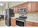 A kitchen showcasing stainless steel appliances, wooden cabinets, and light countertops at 9609 E Monte Ave, Mesa, AZ 85209